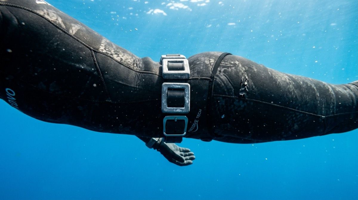 Freediver with a weight belt hovering at neutral buoyancy